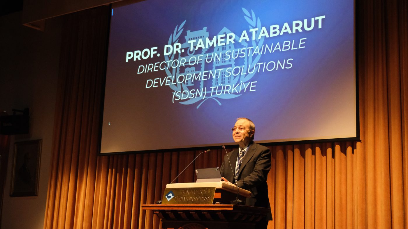 Prof. Dr. Tamer Atabarut speaking at the Albert Long Hall podium